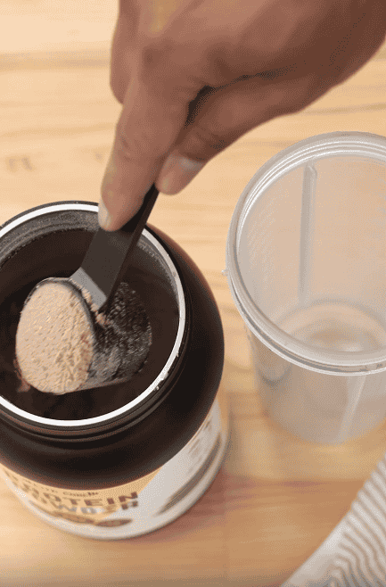A person using EliteCore Healthy Chocolate Protein Powder with BCAAs.